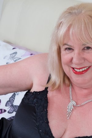 Зрелая британская толстушка Speedy Bee снимает на кровати черный пеньюар в нейлоновых чулках со швом сзади Фото 3